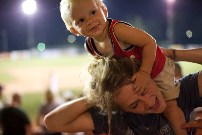 Rachael Waninger of Ferdinand held her one-year-old son, Barrett Waninger on her shoulders at Thursday night's Bombers' game against the Owensboro Oilers at League Stadium in Huntingburg. The Bombers won 11-1.